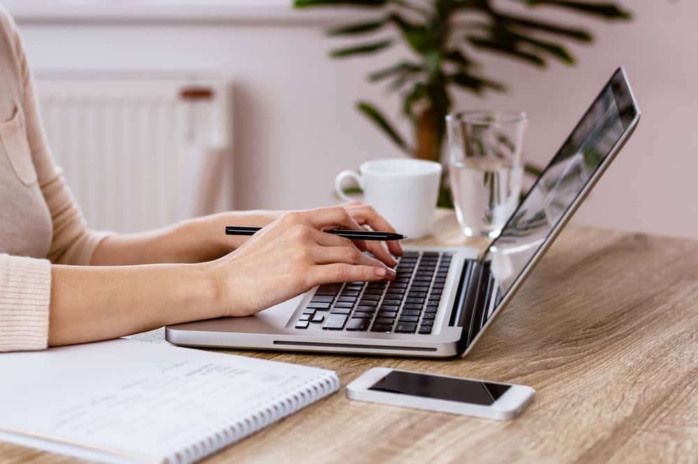 Close-up of young woman typing on laptop