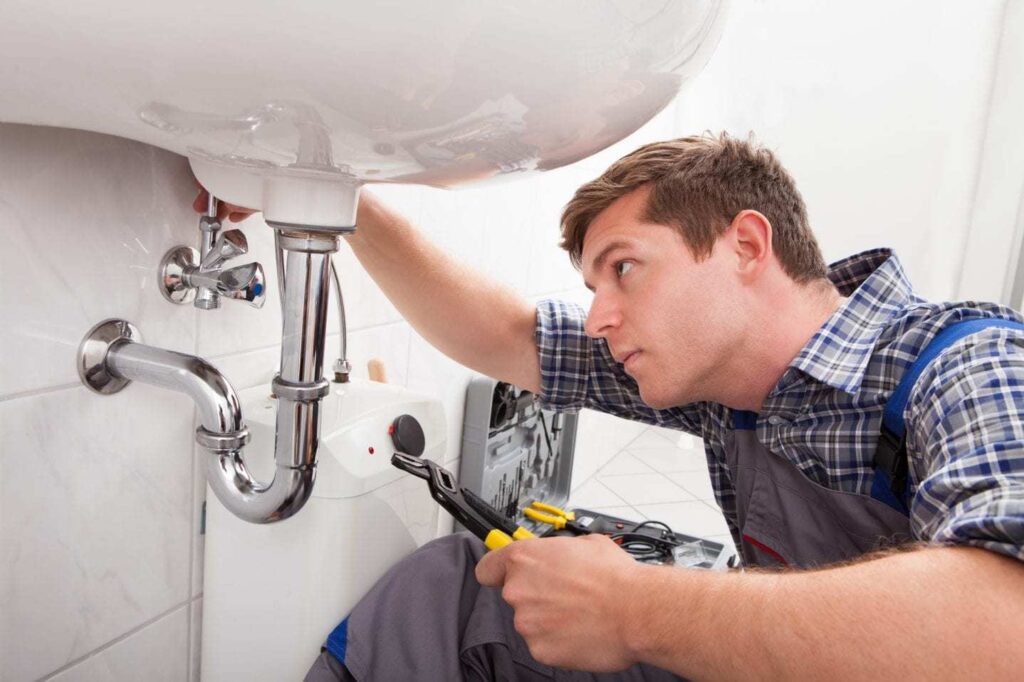 Plumber Working Beneath Sink